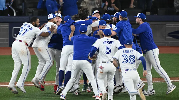 Blue Jays team celebrating after winning ALCS Game 7 against Mariners. Photo credit: SportsIllusrated.